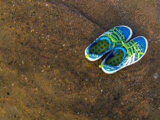 a pair of shoes sitting on top of a dirt field