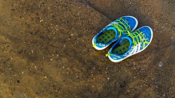 a pair of shoes sitting on top of a dirt field
